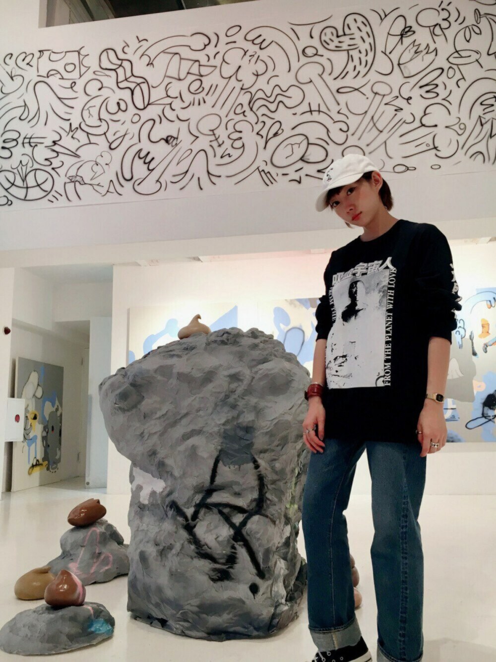 ブラック系のスニーカー、ブラウン系のブレスレット、ゴールド系のアナログ腕時計を着用したレディースの秋コーディネートの1枚目の写真