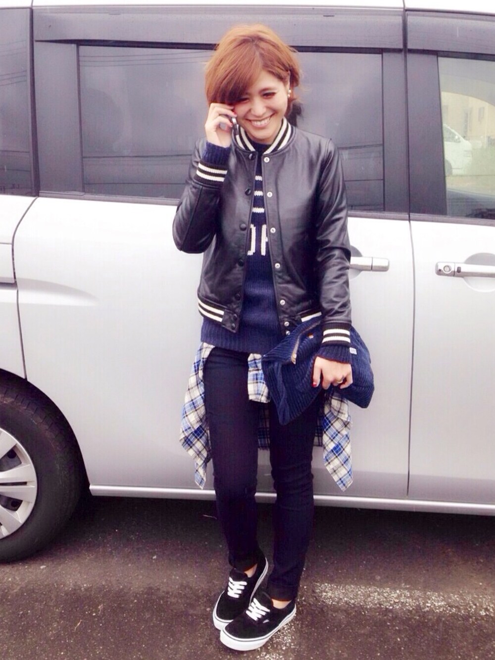 ブルー系のニット/セーター、ブラック系のライダースジャケット、ブルー系のデニムパンツを着用したレディースの秋コーディネートの1枚目の写真