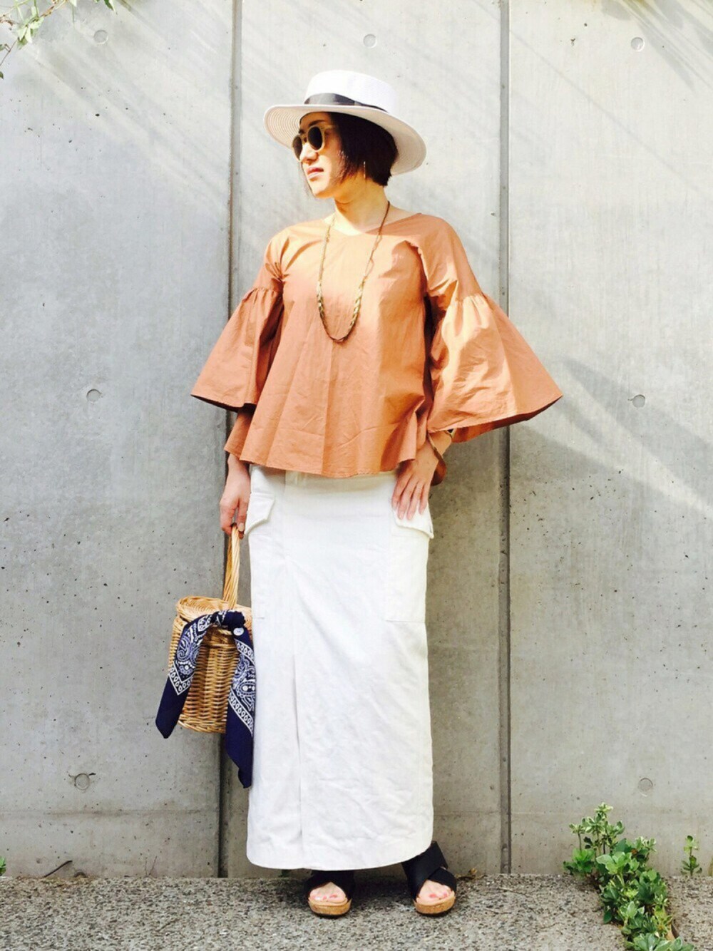 レッド系のシャツ/ブラウス、ブルー系のかごバッグ、ホワイト系のデニムスカートを着用したレディースの夏コーディネートの1枚目の写真