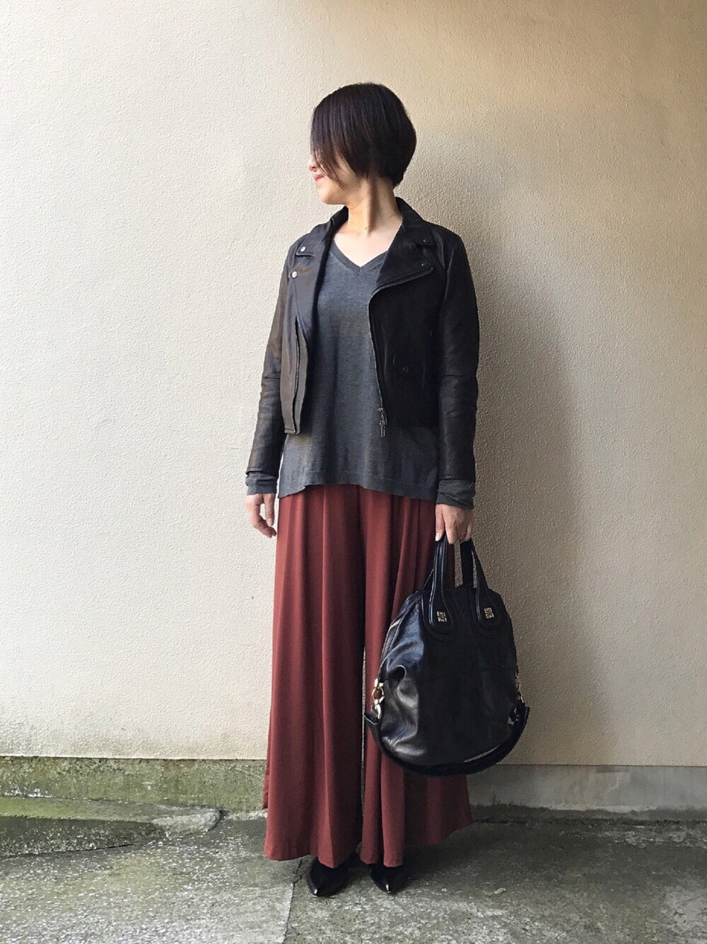 ブラック系のライダースジャケット、グレー系のTシャツ/カットソー、ブラウン系のパンツを着用したレディースの秋コーディネートの1枚目の写真