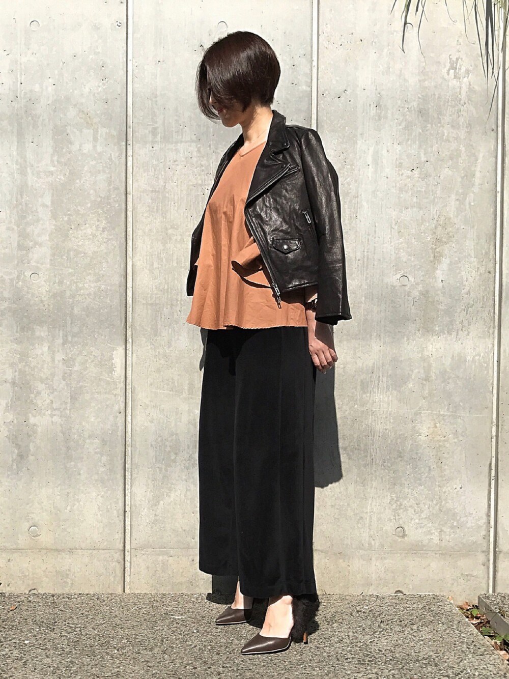 ブラック系のライダースジャケット、レッド系のシャツ/ブラウス、ブラック系のその他パンツを着用したレディースの秋コーディネートの1枚目の写真