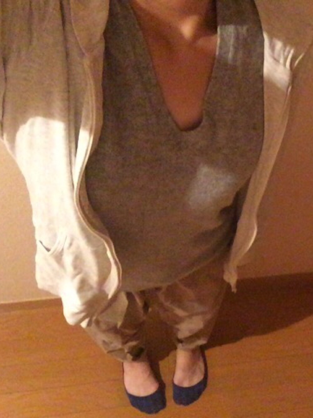 グレー系のニット/セーター、ホワイト系のパーカー、ベージュ系のチノパンツを着用したレディースの秋コーディネートの1枚目の写真