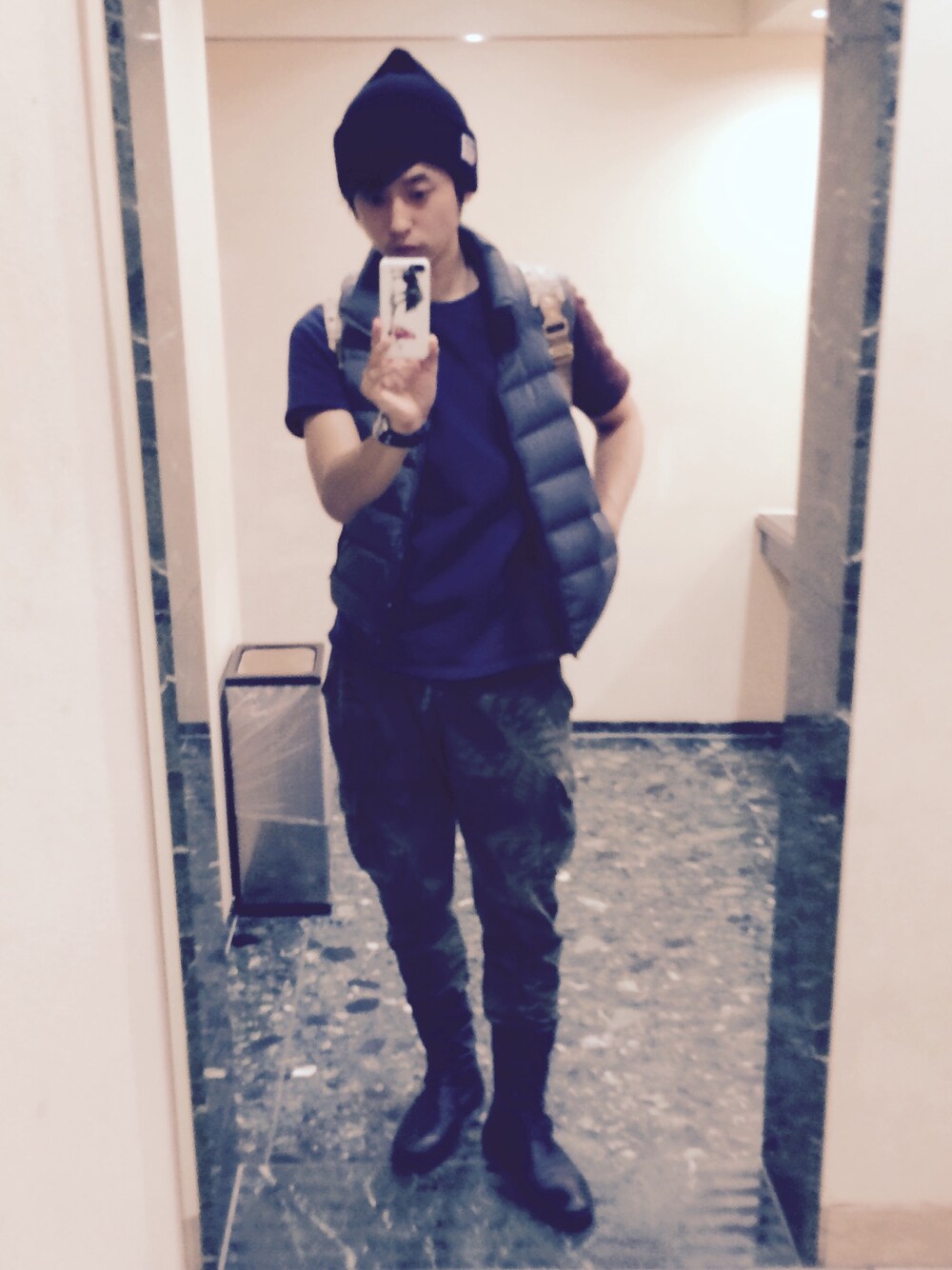 ブルー系のTシャツ/カットソー、グレー系のダウンベスト、グリーン系のその他パンツを着用したメンズの秋コーディネートの1枚目の写真