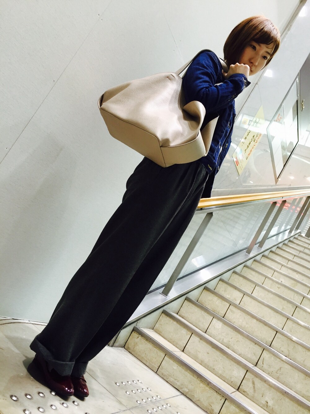 グレー系のその他パンツ、ブルー系のデニムジャケット、グレー系のハンドバッグを着用したレディースの秋コーディネートの1枚目の写真