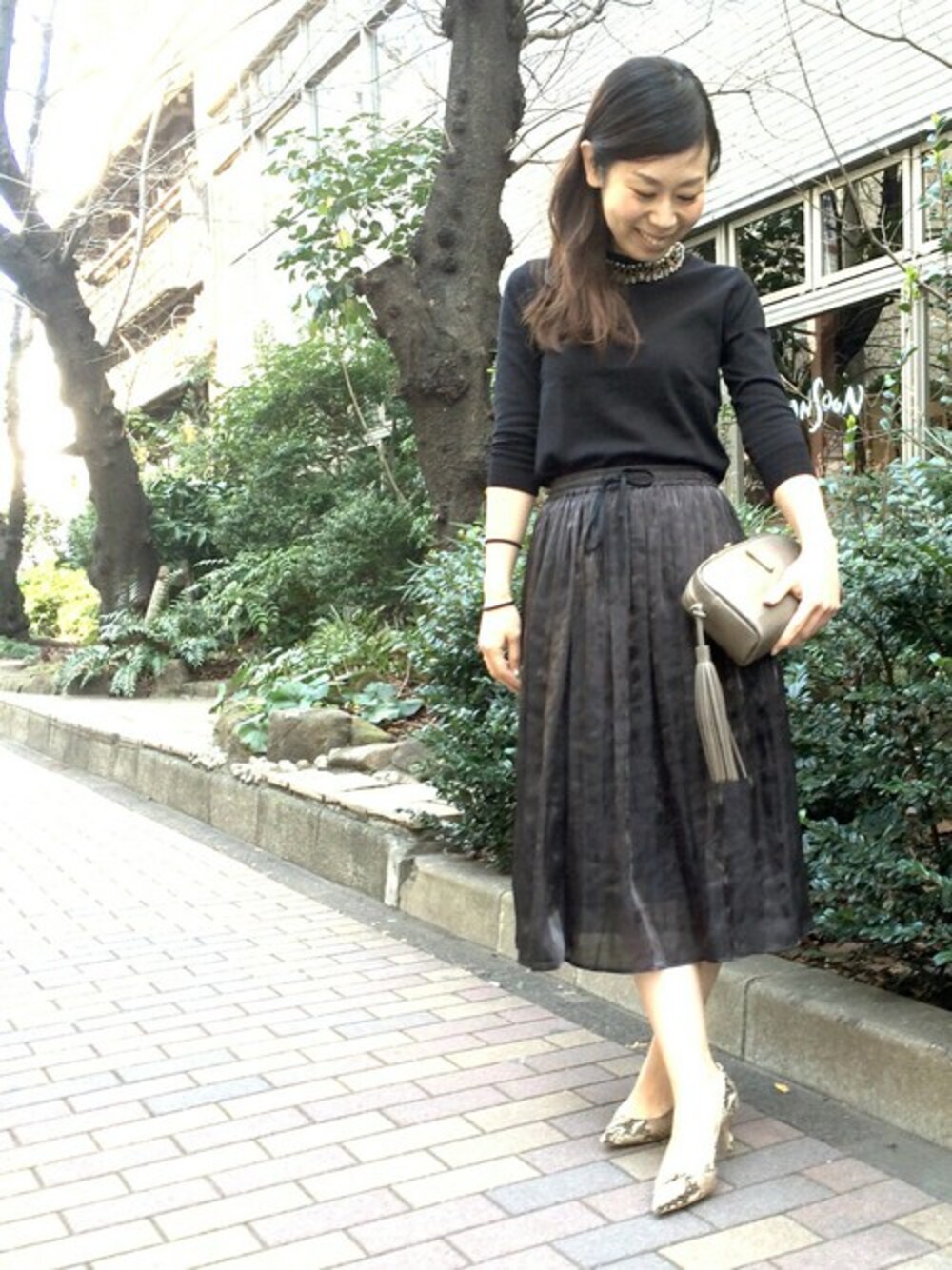 ブラック系のニット/セーター、ブラック系のスカート、ベージュ系のパンプスを着用したレディースの冬コーディネートの1枚目の写真