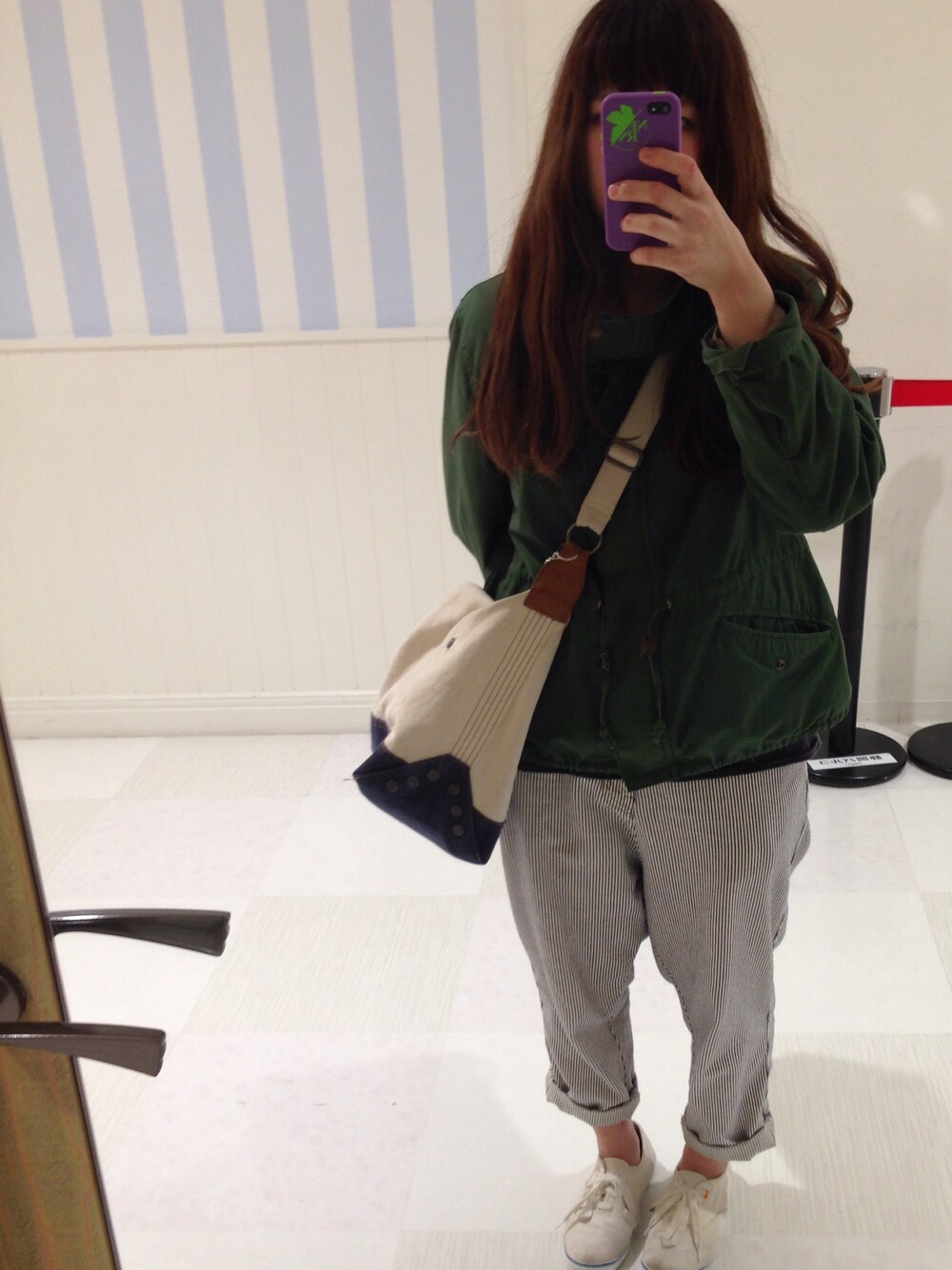 グリーン系のミリタリージャケット、ホワイト系のデニムパンツを着用したレディースの春コーディネートの1枚目の写真