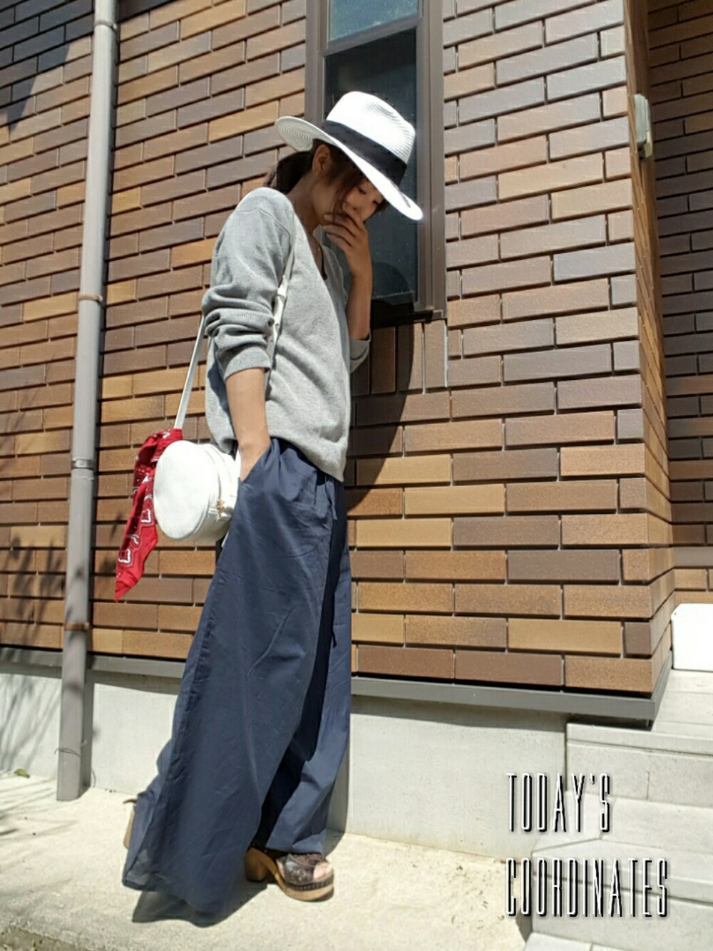 グレー系のトップス、ブルー系のその他パンツ、ブラック系のサンダルを着用したレディースの春コーディネートの1枚目の写真