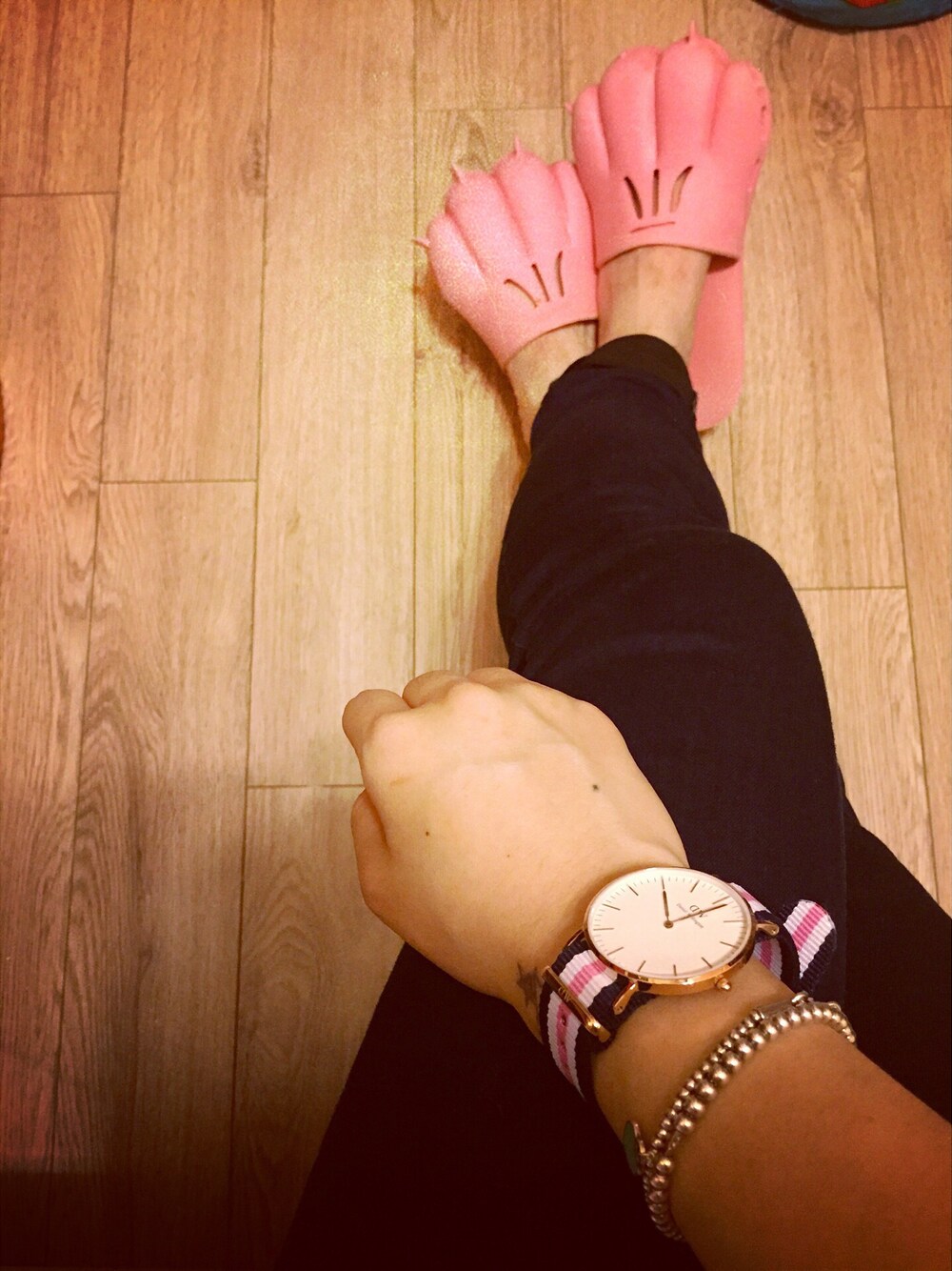 ピンク系のアナログ腕時計、ホワイト系のブレスレットを着用したレディースの冬コーディネートの1枚目の写真