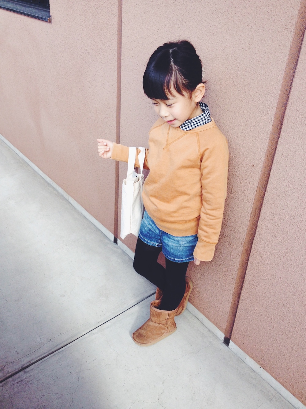 イエロー系のスウェット、ブルー系のシャツ/ブラウス、ホワイト系のトートバッグを着用したキッズの冬コーディネートの1枚目の写真