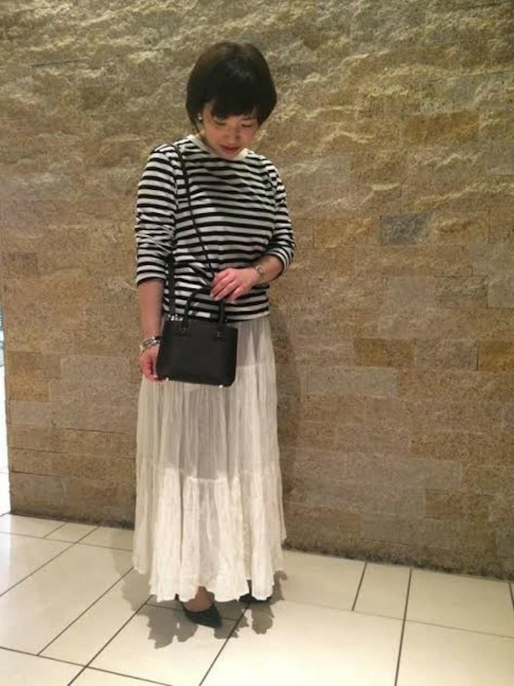 ブラック系のショルダーバッグ、ブラック系のTシャツ/カットソーを着用したレディースの冬コーディネートの1枚目の写真