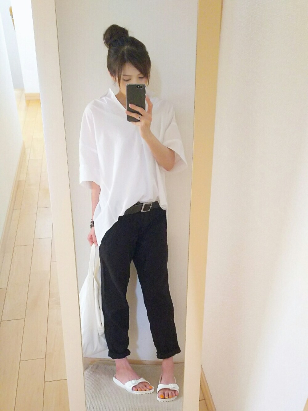 ホワイト系のサンダル、ホワイト系のシャツ/ブラウス、グレー系のブレスレットを着用したレディースの夏コーディネートの1枚目の写真