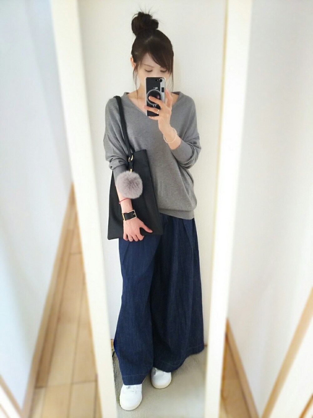 グレー系のニット/セーター、ブルー系のデニムパンツ、ブラック系のトートバッグを着用したレディースの秋コーディネートの1枚目の写真