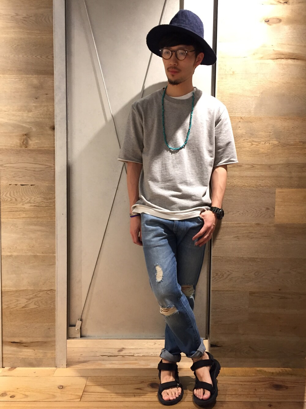 ホワイト系のスウェット、ブルー系のパンツ、ブラック系のサンダルを着用したメンズの春コーディネートの1枚目の写真