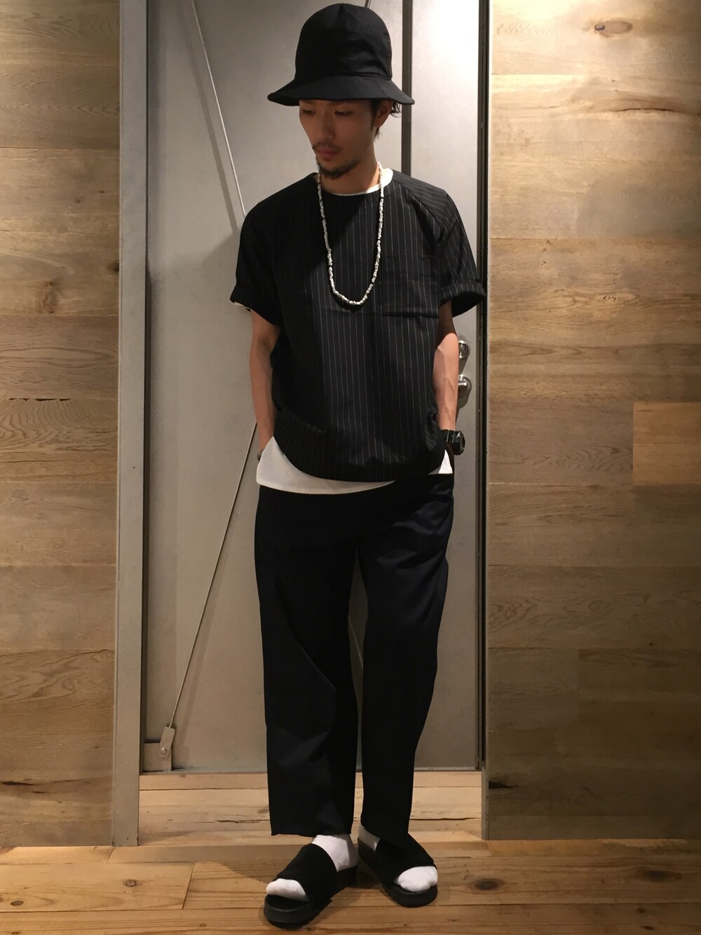 ブラック系のサンダル、ブルー系のチノパンツ、ブラック系のシャツ/ブラウスを着用したメンズの夏コーディネートの1枚目の写真