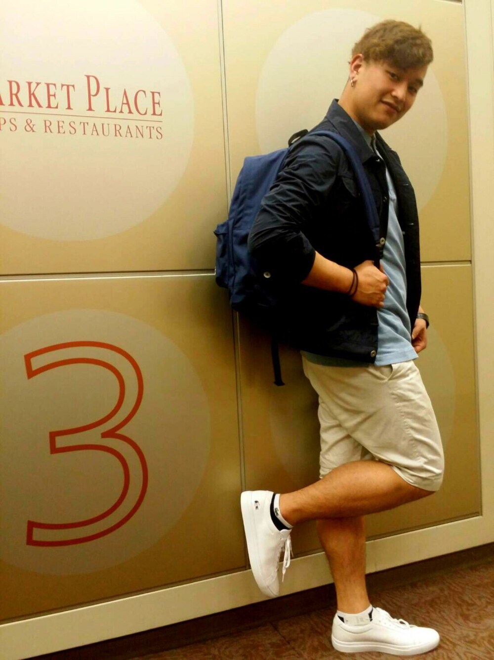 ブルー系のバックパック/リュック、ブルー系のブルゾン、ホワイト系のチノパンツを着用したメンズの春コーディネートの1枚目の写真