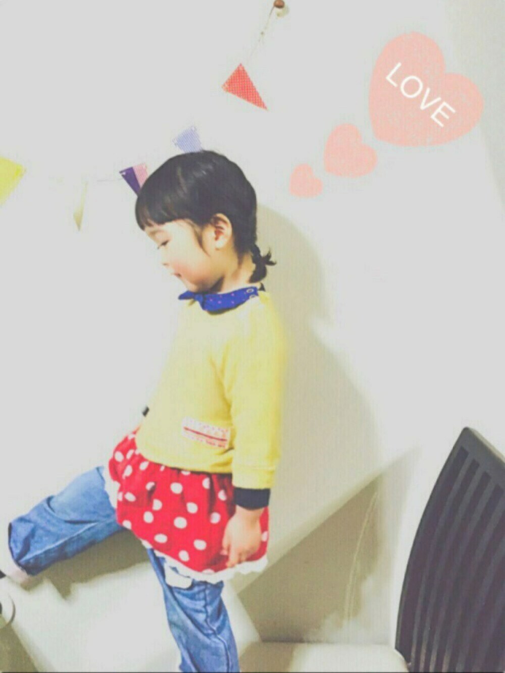 イエロー系のワンピース、ブルー系のデニムパンツ、ピンク系のその他を着用したキッズの冬コーディネートの1枚目の写真