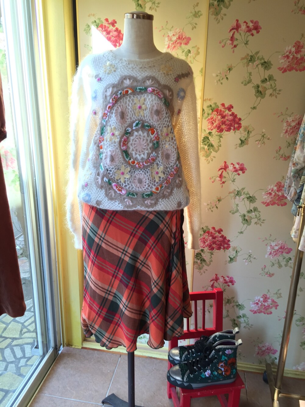 ホワイト系のニット/セーター、オレンジ系のスカート、グリーン系のスニーカーを着用したレディースの冬コーディネートの1枚目の写真