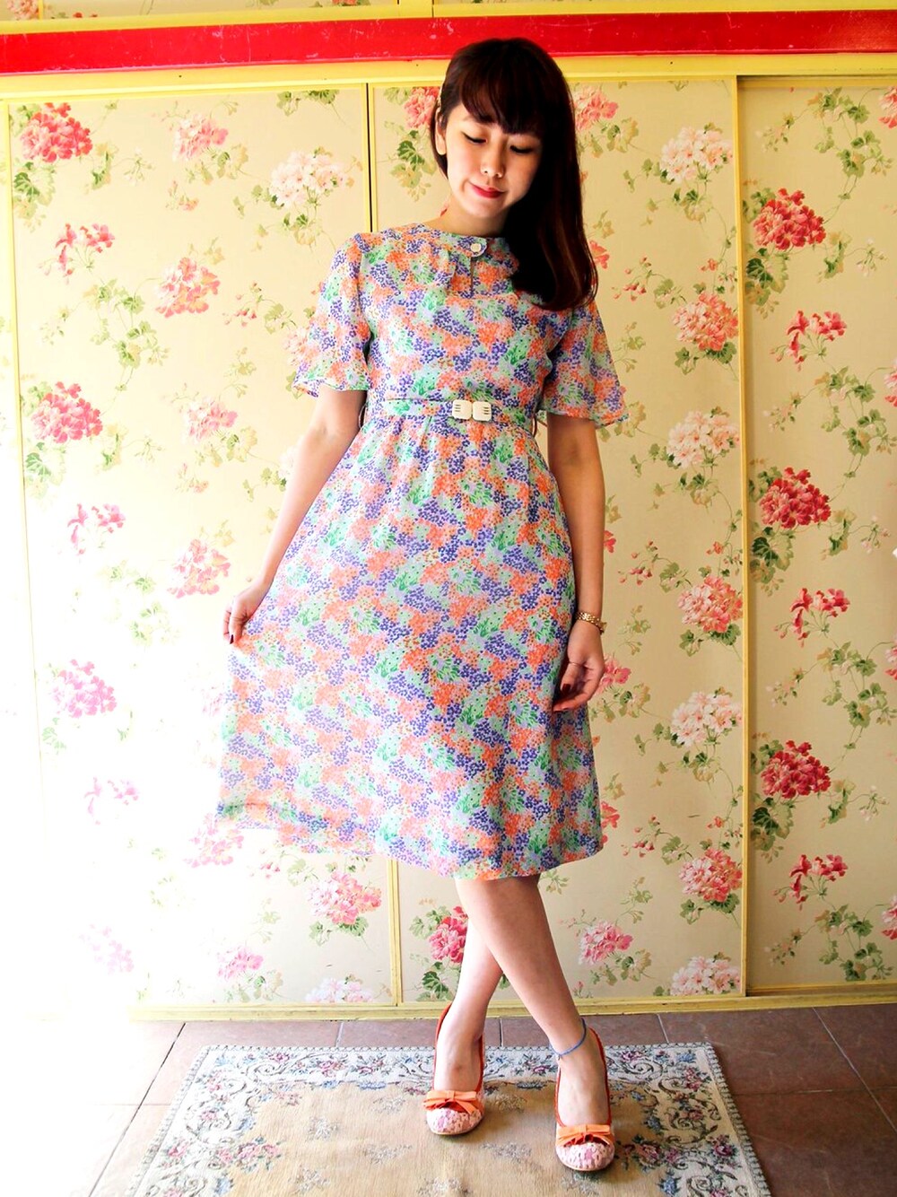 パープル系のワンピース、パープル系のワンピース、オレンジ系のパンプスを着用したレディースの春コーディネートの1枚目の写真