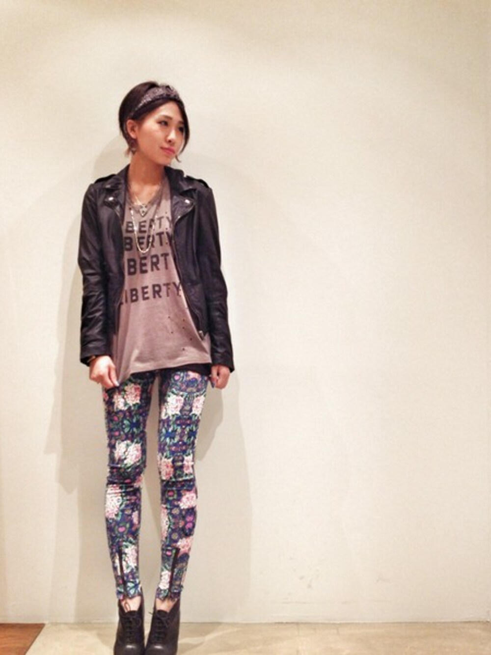 グレー系のタンクトップ、ブラック系のライダースジャケット、ブラック系のブーティを着用したレディースの秋コーディネートの1枚目の写真