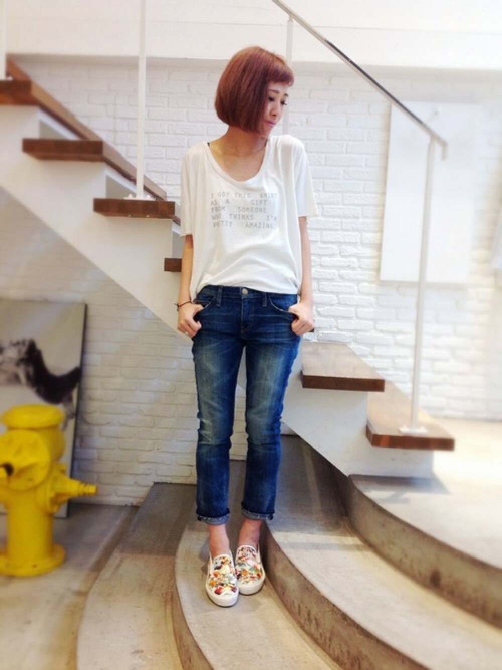 ブルー系のデニムパンツ、ホワイト系のTシャツ/カットソー、ホワイト系のスニーカーを着用したレディースの春コーディネートの1枚目の写真