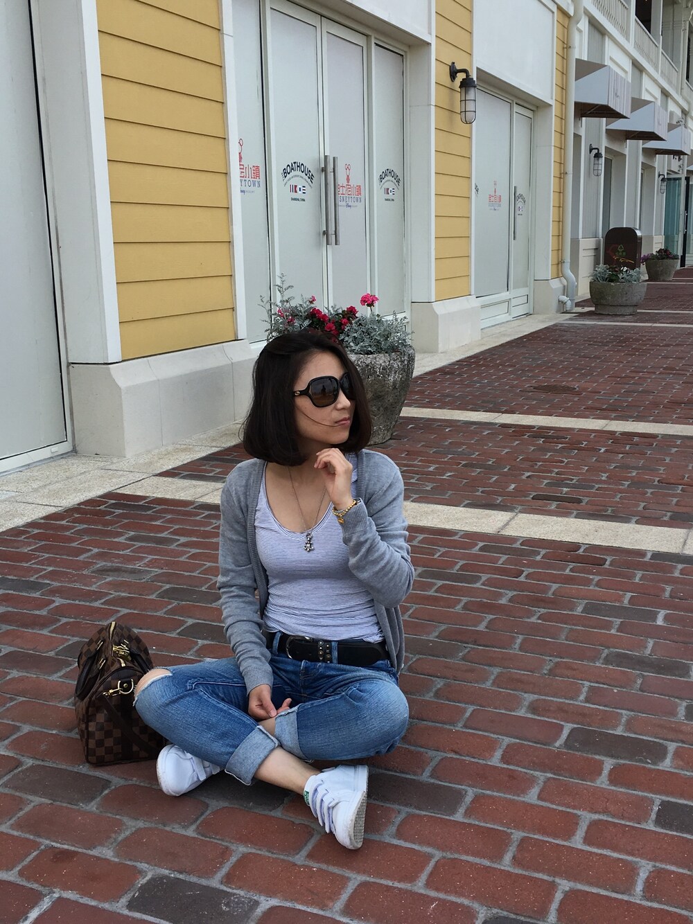 ホワイト系のスニーカー、ブルー系のデニムパンツ、グレー系のピーコートを着用したレディースの夏コーディネートの1枚目の写真