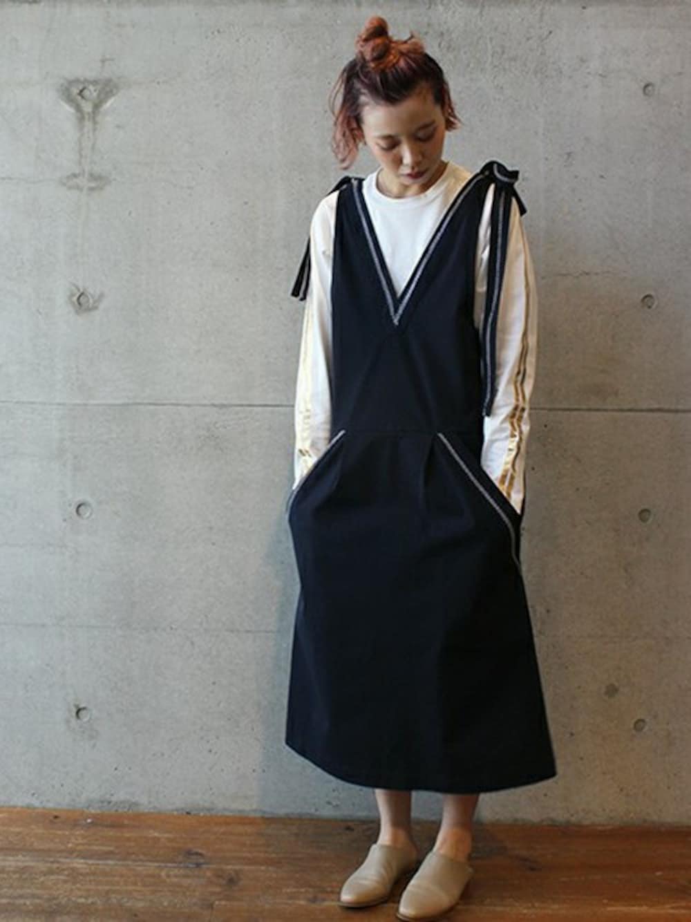 ベージュ系のジャンパースカート、ホワイト系のTシャツ/カットソーを着用したレディースの春コーディネートの1枚目の写真