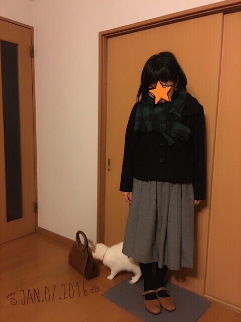 ブラック系のその他アウター、グレー系のスカート、ブラウン系のパンプスを着用したレディースの冬コーディネートの1枚目の写真