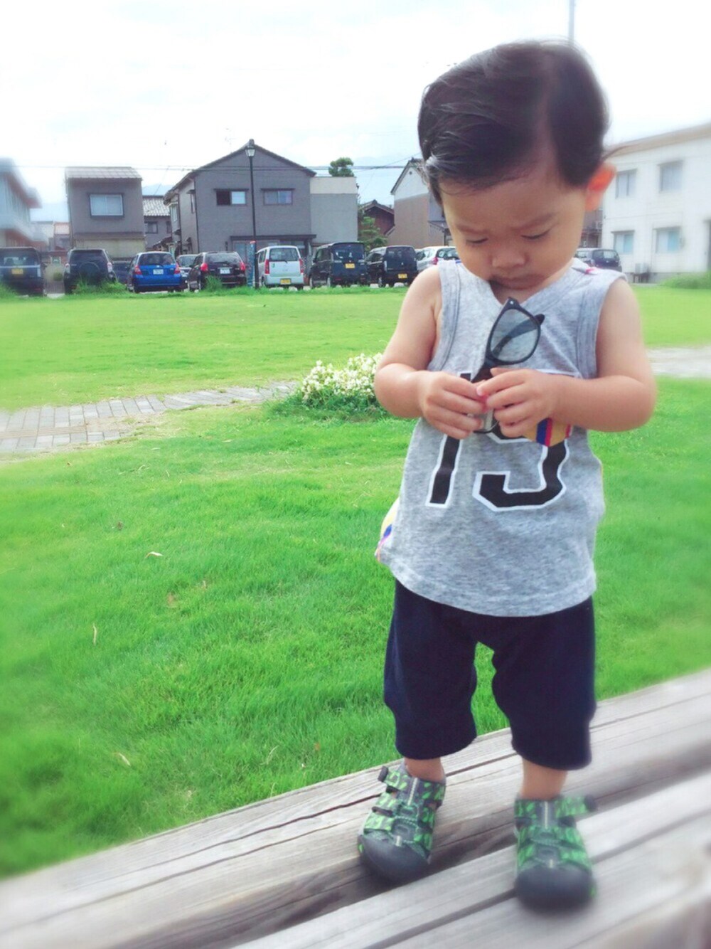 ブラック系のサンダル、グリーン系のチュニック、グレー系のタンクトップを着用したキッズの夏コーディネートの1枚目の写真