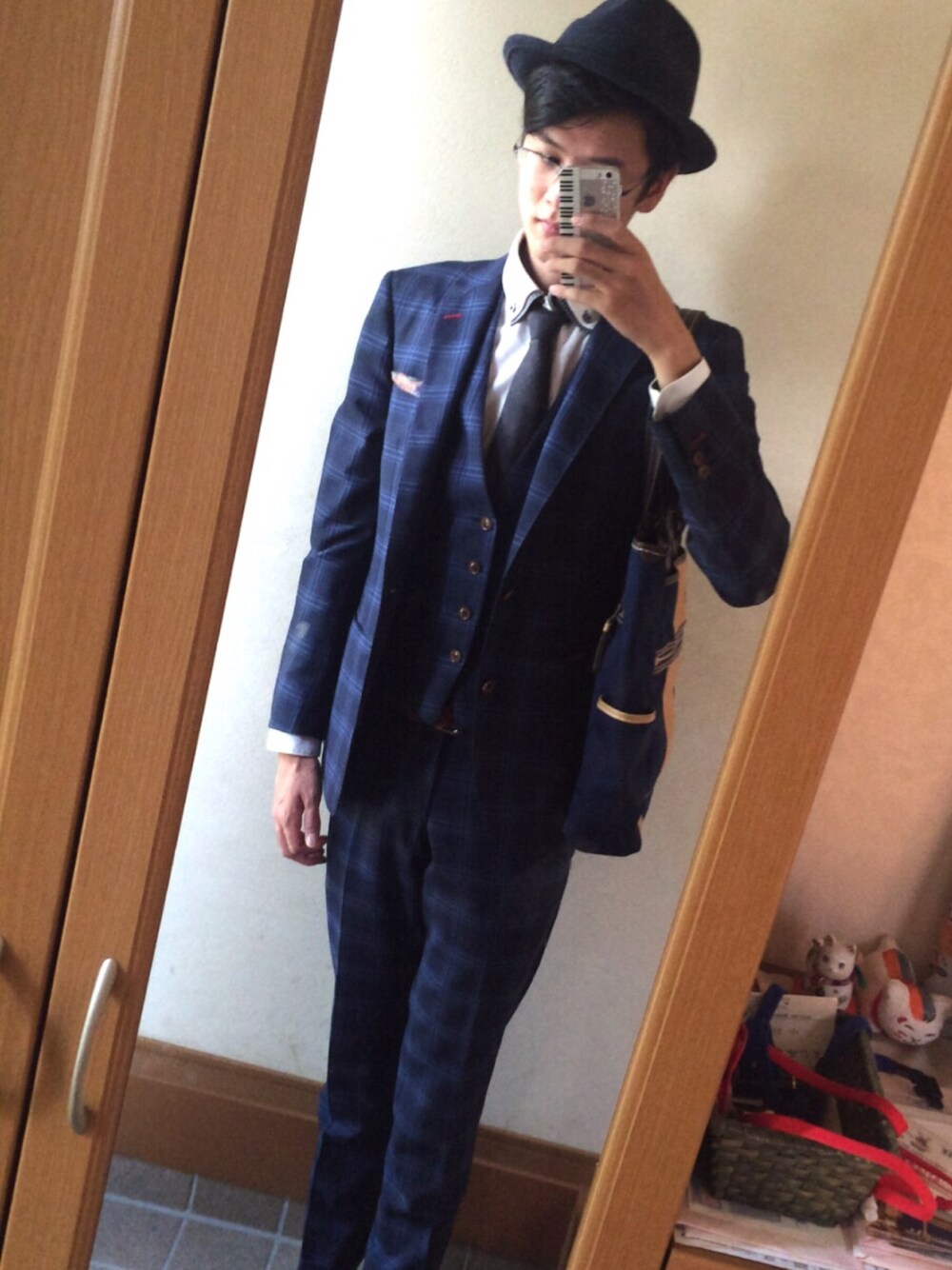 グレー系のネクタイ、ブルー系のスーツジャケット、ブルー系のハットを着用したメンズの秋コーディネートの1枚目の写真