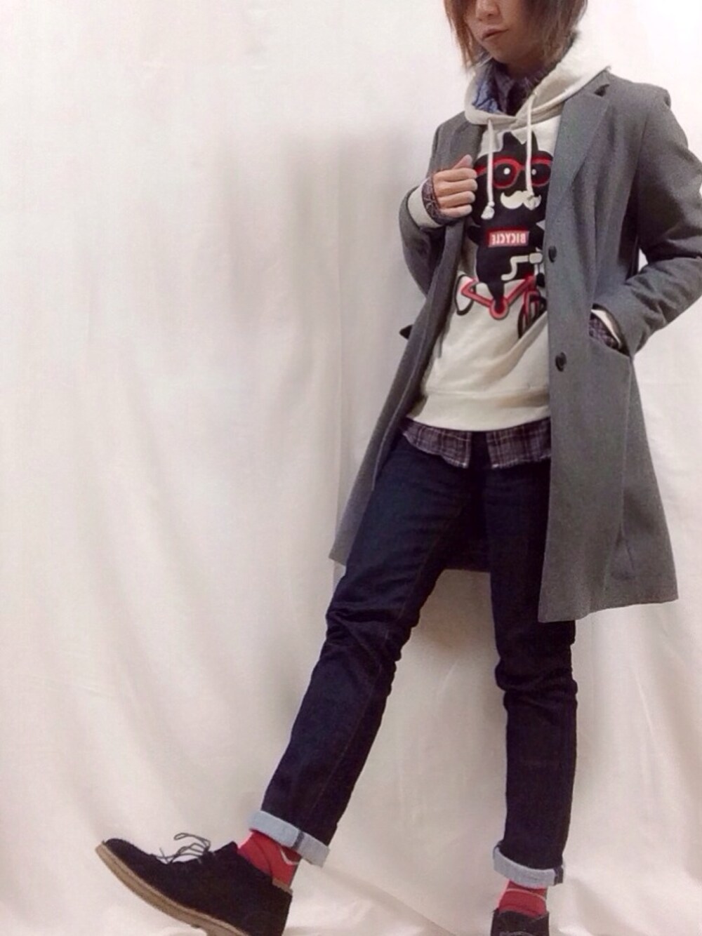 グレー系のチェスターコート、ブルー系のデニムパンツ、ホワイト系のパーカーを着用したメンズの冬コーディネートの1枚目の写真