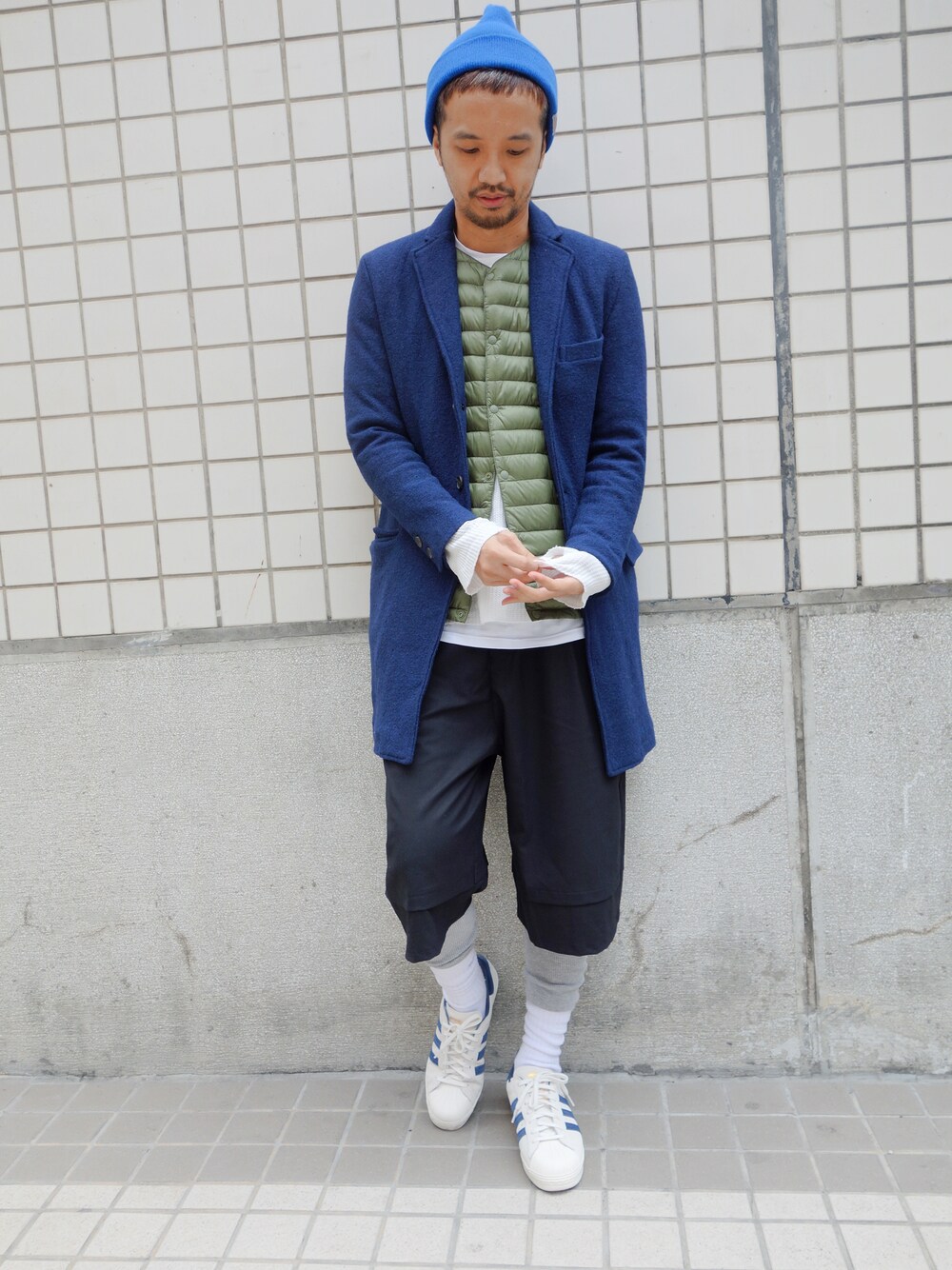 ブラック系のスニーカー、ブルー系のピーコート、ホワイト系のTシャツ/カットソーを着用したメンズの冬コーディネートの1枚目の写真