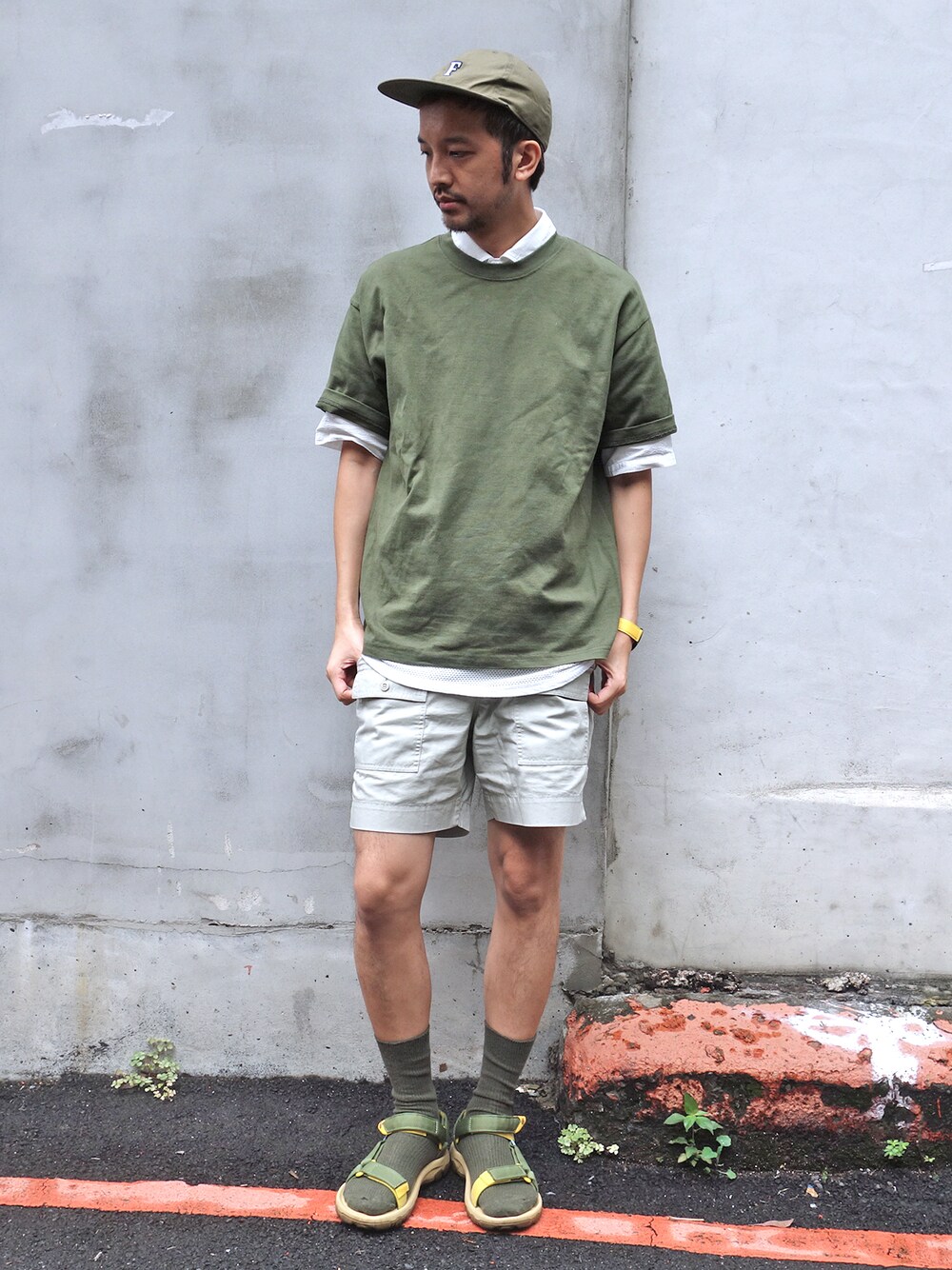 グリーン系のキャップを着用したメンズの夏コーディネートの1枚目の写真