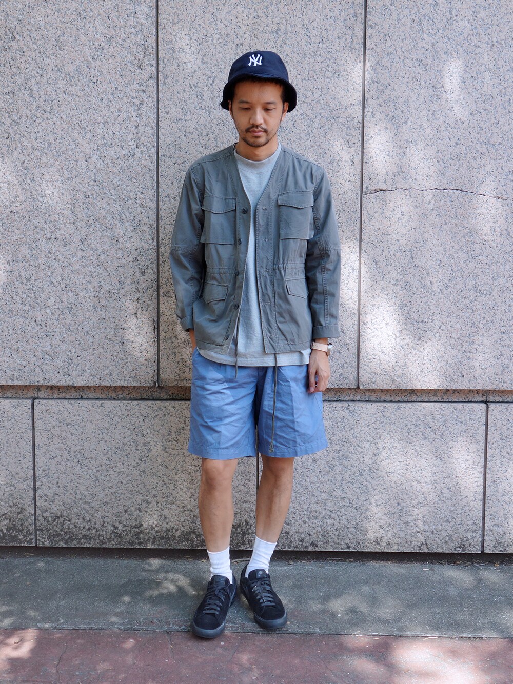 グリーン系のキャップを着用したメンズの秋コーディネートの1枚目の写真