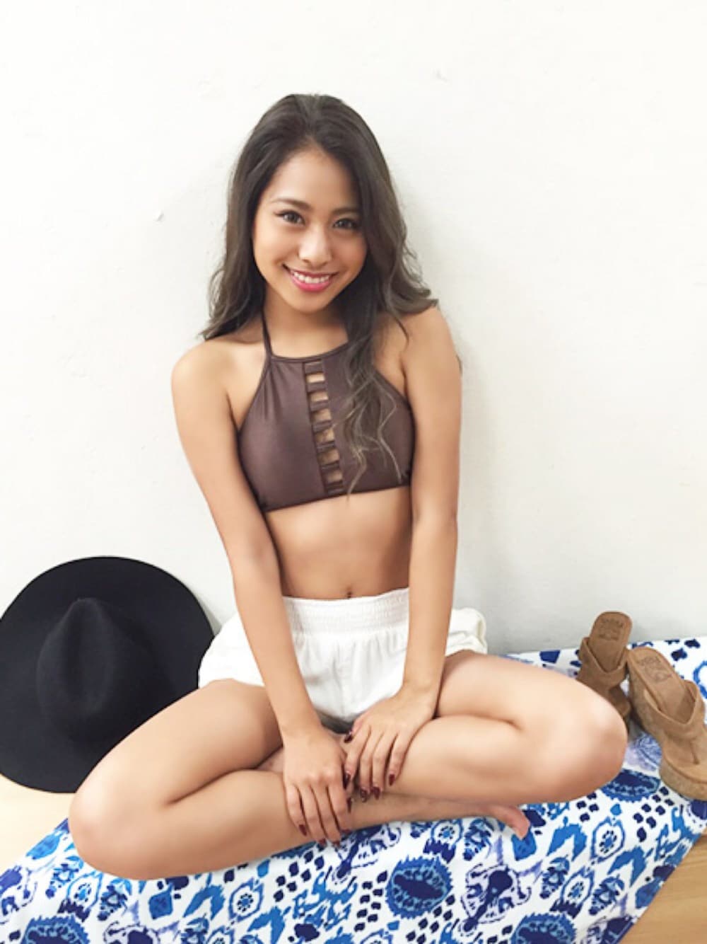 ブラウン系のビーチサンダル、ブラウン系の水着、ホワイト系のスイムグッズを着用したレディースの秋コーディネートの1枚目の写真