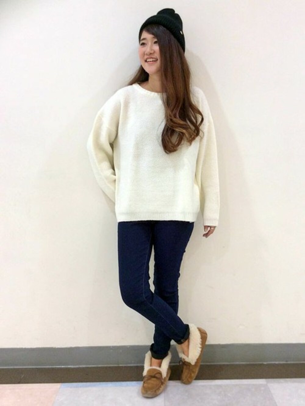 ホワイト系のニット/セーター、ブルー系のデニムパンツ、ブラック系のニットキャップ/ビーニーを着用したレディースの冬コーディネートの1枚目の写真