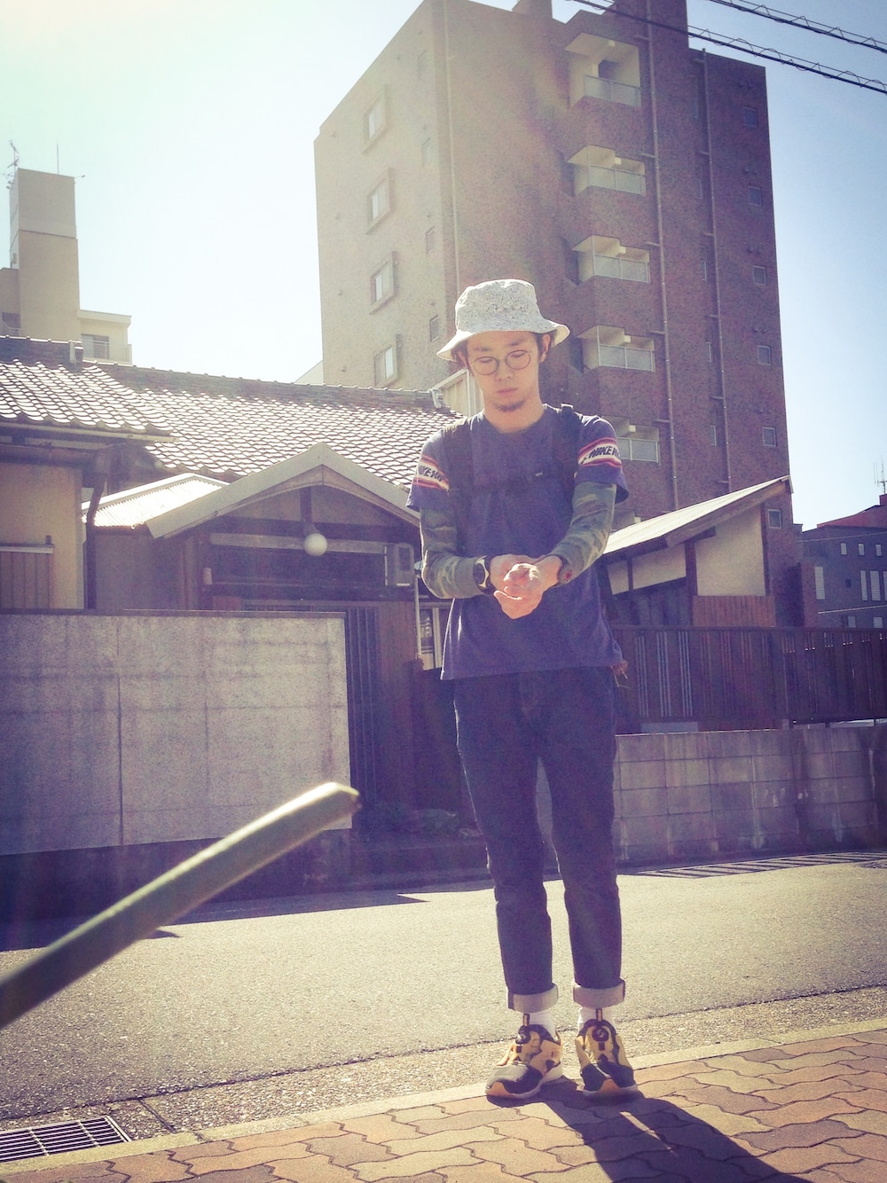 ブラック系のスニーカー、ホワイト系のハットを着用したメンズの秋コーディネートの1枚目の写真