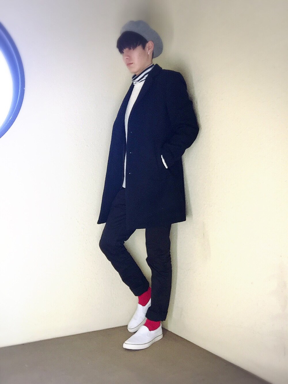 ブルー系のチェスターコート、ホワイト系のニット/セーター、ブラック系のTシャツ/カットソーを着用したメンズの冬コーディネートの1枚目の写真