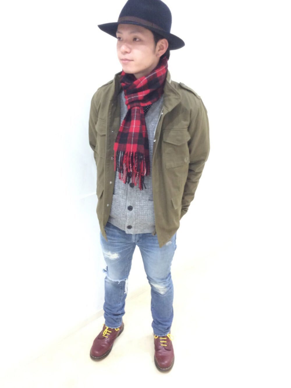 グリーン系のミリタリージャケット、グレー系のカーディガン/ボレロ、レッド系のマフラーを着用したメンズの冬コーディネートの1枚目の写真