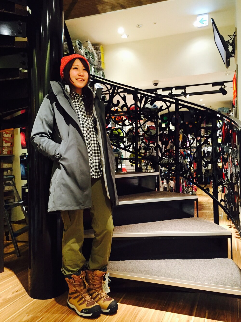 グレー系のダウンジャケット/コート、レッド系のニットキャップ/ビーニーを着用したレディースの冬コーディネートの1枚目の写真