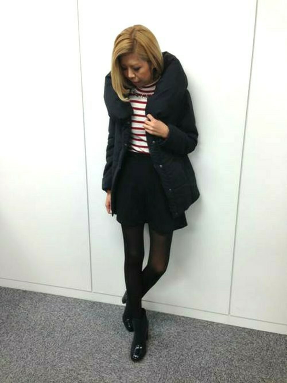 ブラック系のブルゾン、レッド系のTシャツ/カットソー、ブラック系のスカートを着用したレディースの冬コーディネートの1枚目の写真