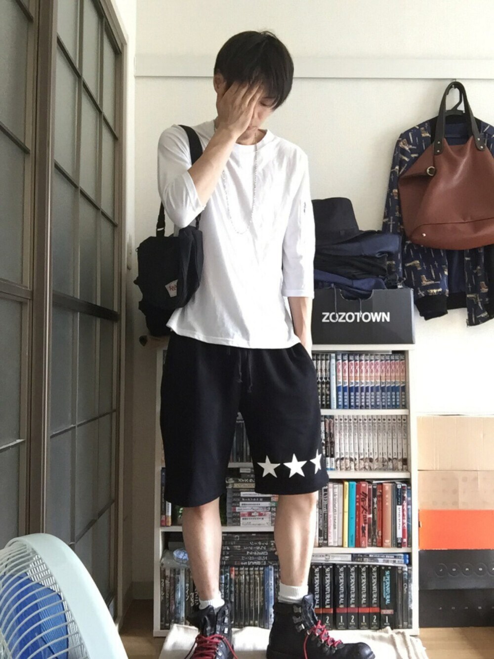 ホワイト系のTシャツ/カットソー、ブラック系のブーツ、ブラック系のショルダーバッグを着用したメンズの夏コーディネートの1枚目の写真