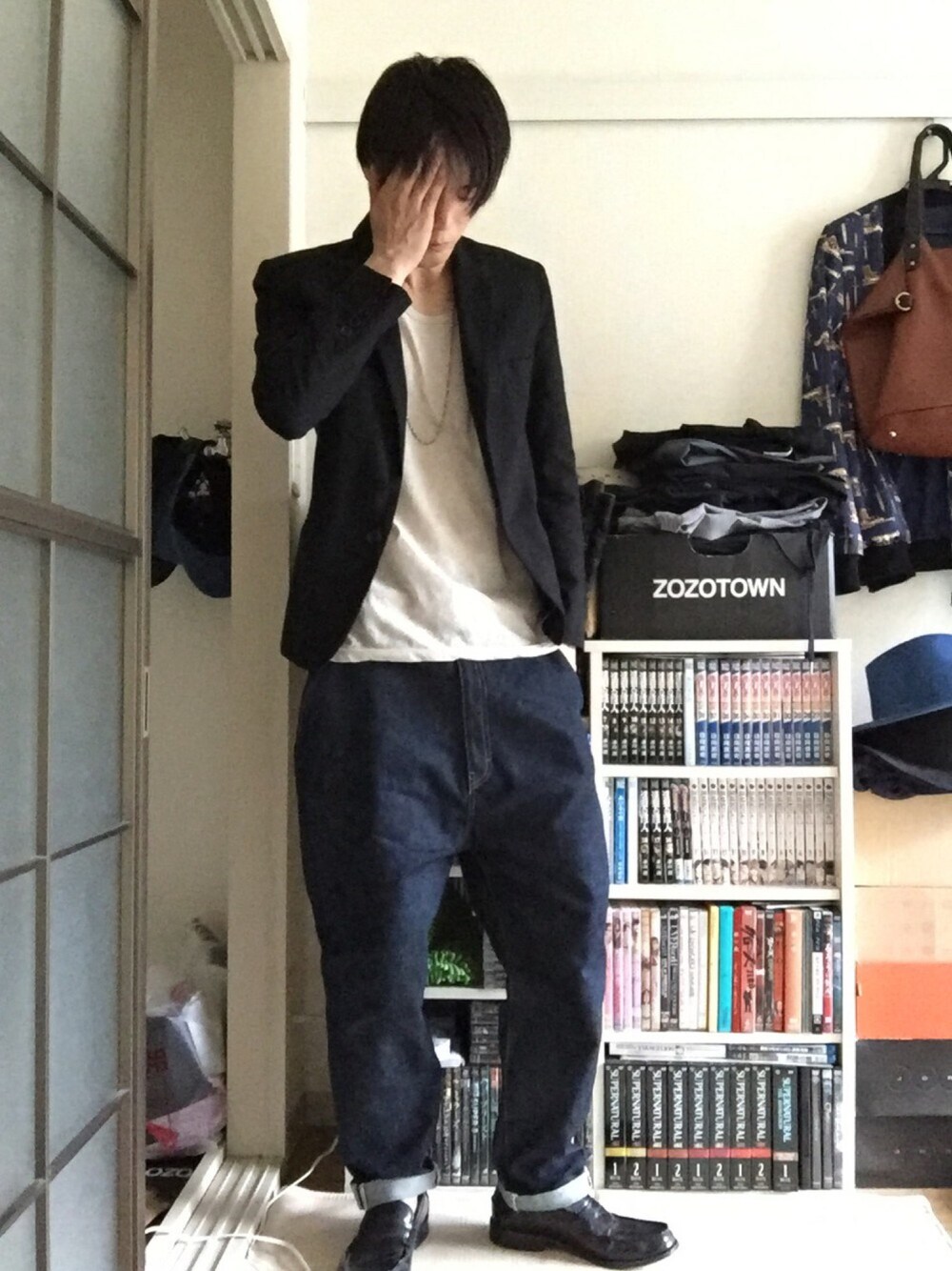 ブラック系のテーラードジャケット、グレー系のTシャツ/カットソー、ブルー系のデニムパンツを着用したメンズの秋コーディネートの1枚目の写真