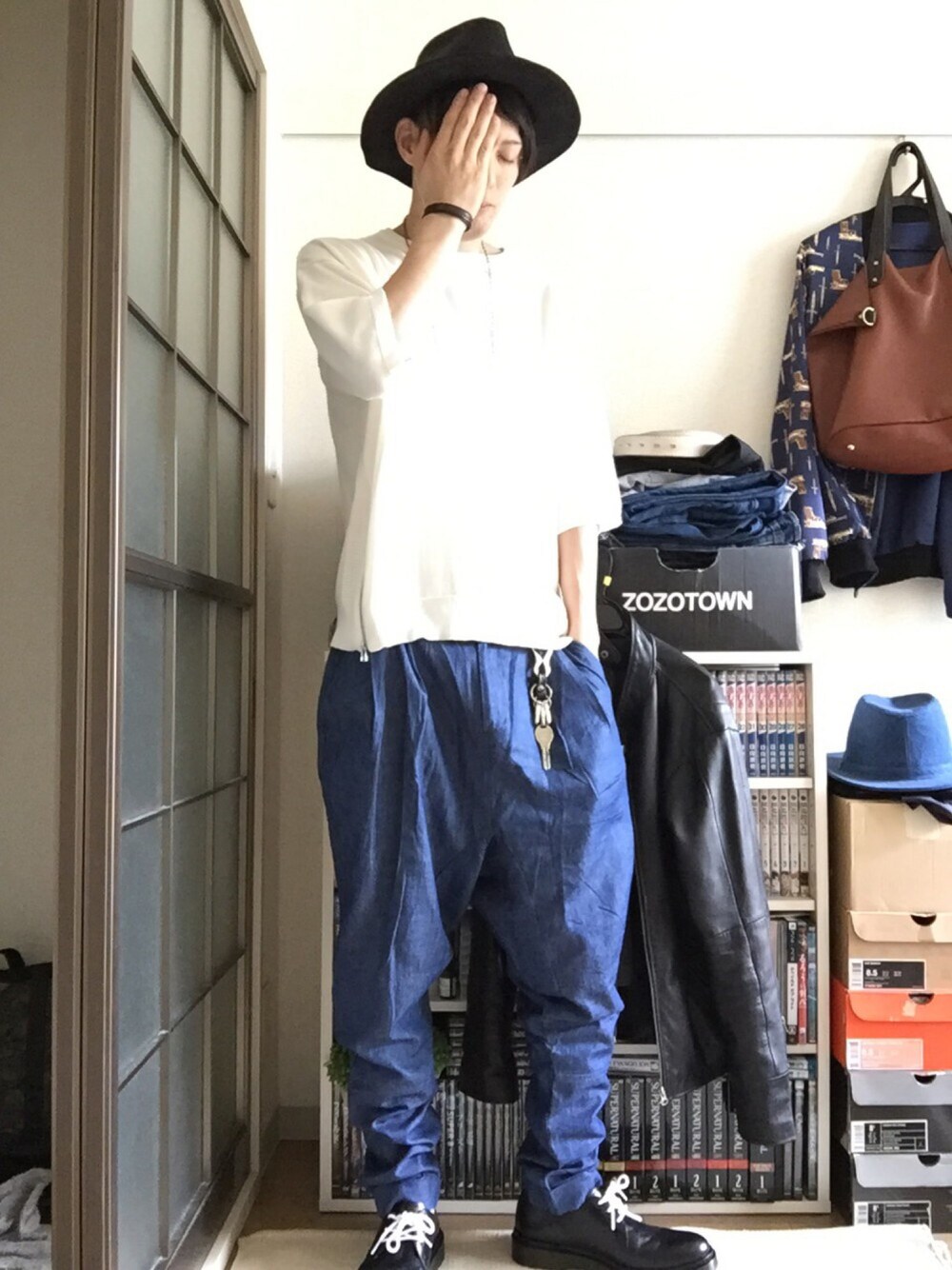 ホワイト系のニット/セーター、ブルー系のその他パンツ、ブラック系のブーツを着用したメンズの秋コーディネートの1枚目の写真