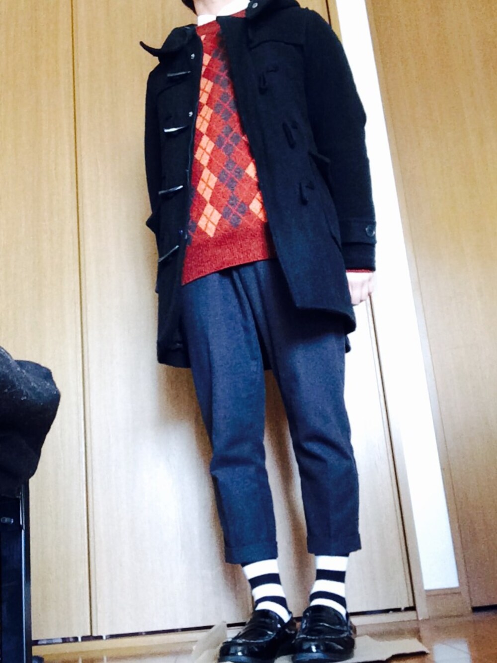 ブラック系のダッフルコート、レッド系のニット/セーター、シャツ/ブラウスを着用したメンズの冬コーディネートの1枚目の写真