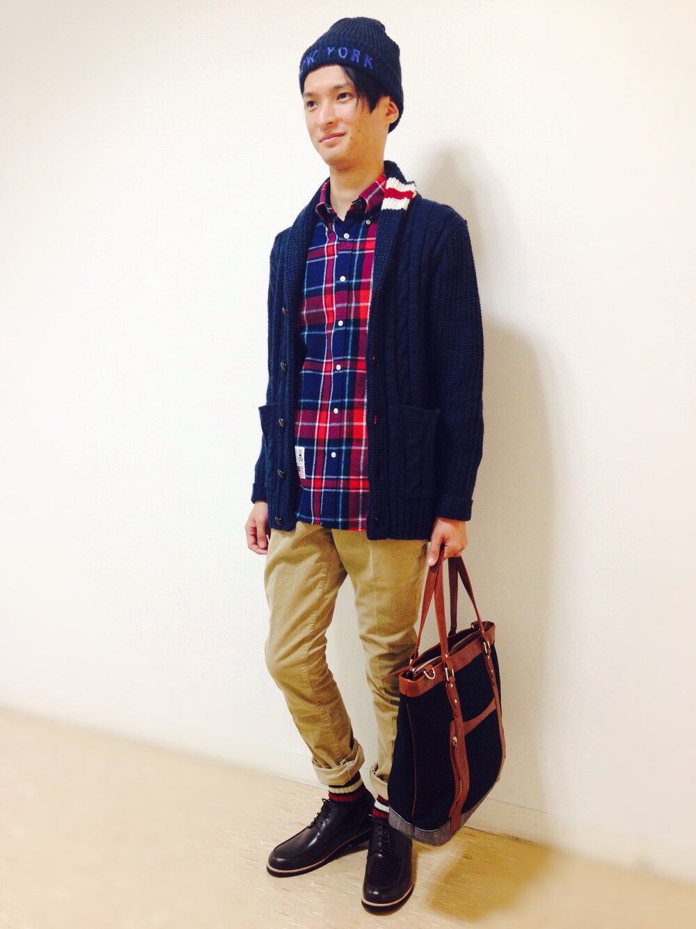 ブルー系のカーディガン/ボレロ、レッド系のシャツ/ブラウス、ベージュ系のパンツを着用したメンズの秋コーディネートの1枚目の写真
