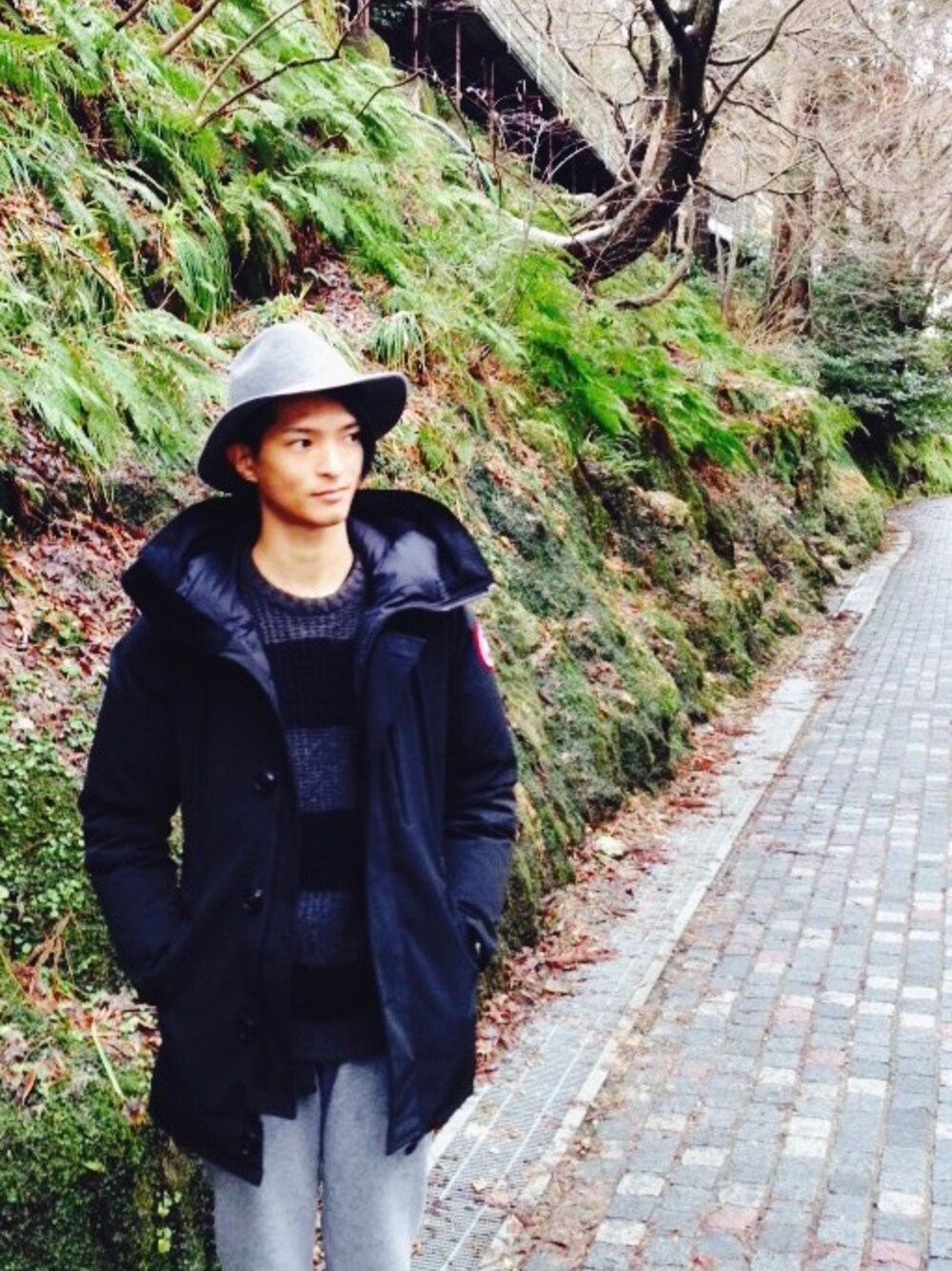 グレー系のパンツ、ブルー系のTシャツ/カットソー、グレー系の帽子を着用したメンズの冬コーディネートの1枚目の写真