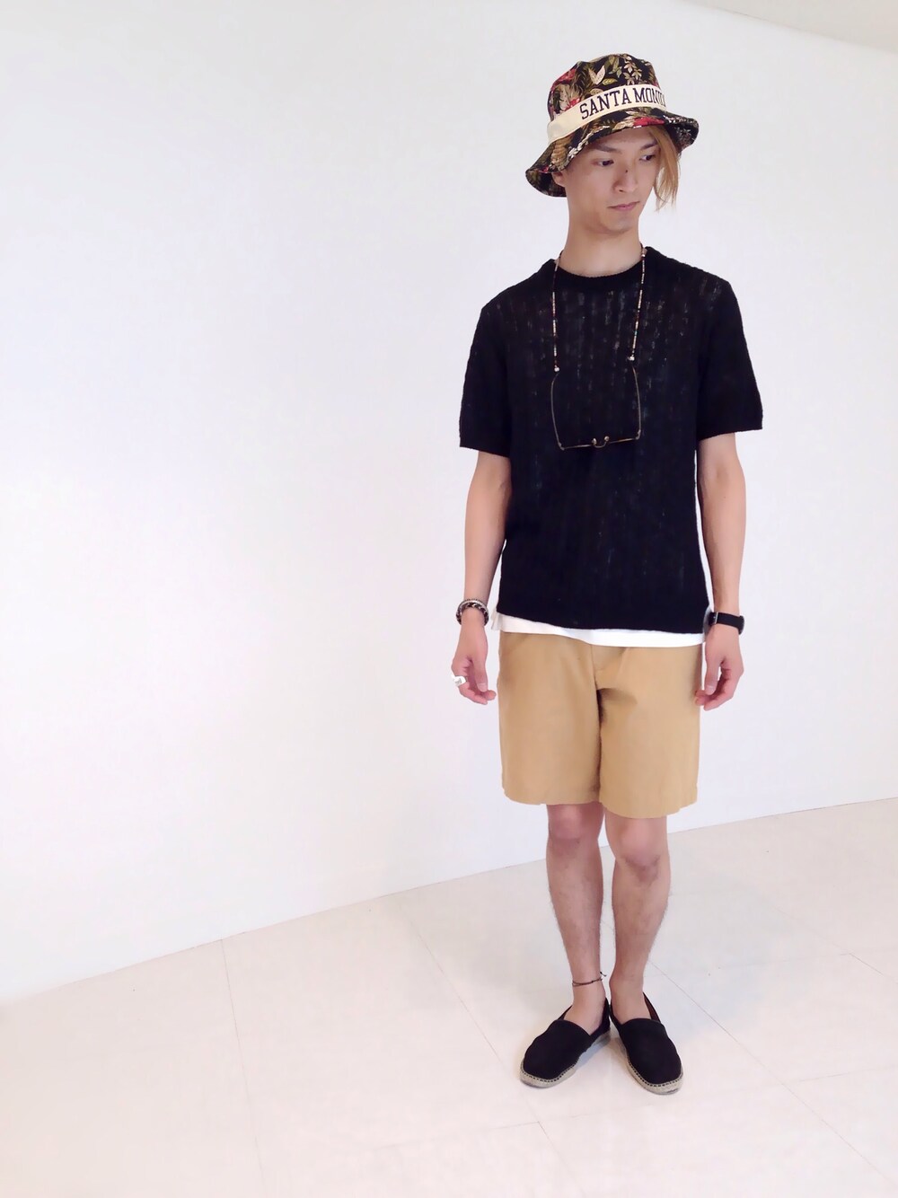 ブラック系のニット/セーター、ベージュ系のその他パンツ、ホワイト系のTシャツ/カットソーを着用したメンズの夏コーディネートの1枚目の写真