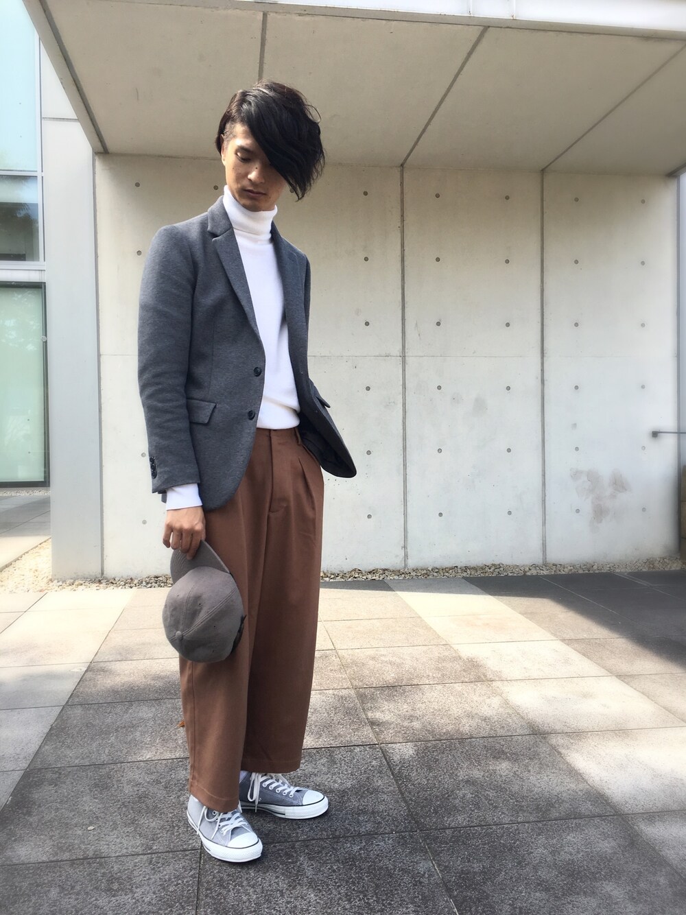 グレー系のテーラードジャケット、ホワイト系のトップス、ブラウン系のその他パンツを着用したメンズの秋コーディネートの1枚目の写真