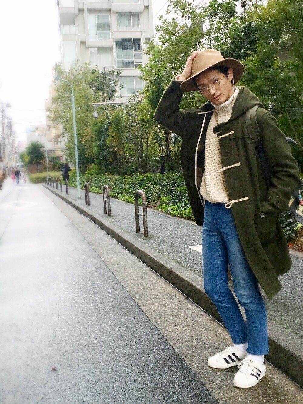 ブルー系のデニムパンツ、ホワイト系のスニーカー、グリーン系のジャケット/アウターを着用したメンズの冬コーディネートの1枚目の写真