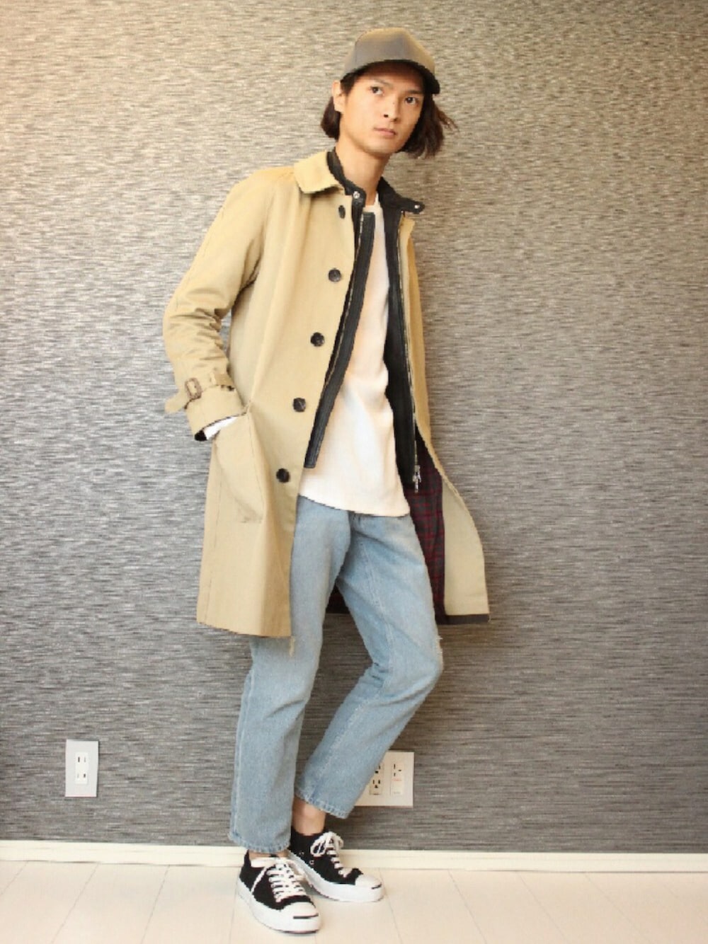 ベージュ系のトレンチコート、ブラック系のライダースジャケット、その他のスニーカーを着用したメンズの冬コーディネートの1枚目の写真